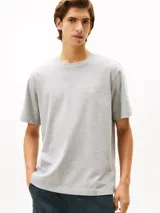 Remera de punto de algodón moteado color gris, con cuello redondo y escudo tonal con el monograma TH bordado en el pecho. Presenta un corte amplio y cinta distintiva en el interior del cuello.