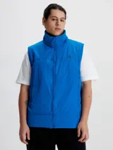 Chaleco acolchado azul eléctrico con cierre frontal, cuello alto y logo de Calvin Klein en el pecho.