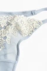 Pack de dos bombachas colaless de malla color celeste con detalles de encaje floral en tono crudo, tiro bajo y laterales finos.