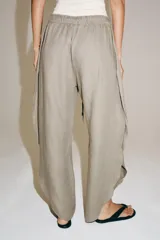 Pantalón ZARA Woman Collection de lino 100%, de tiro medio y color gris claro, con cintura elástica ajustable mediante cordones y bajo redondeado con aberturas laterales.