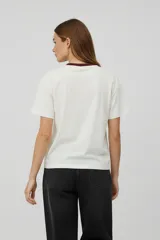 Remera de algodón color blanco con cuello redondo en contraste negro y estampado frontal circular con la leyenda Ocean Club.