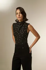 Body sin mangas de algodón, con cuello alto y diseño ajustado al cuerpo, decorado con tachas metálicas plateadas en toda la parte frontal.