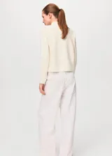 Sweater de punto fino color blanco off-white, con cuello perkins y manga larga, de corte recto.