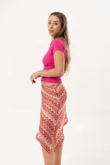 Minifalda asimétrica de crochet con diseño de ondas en tonos rojo, rosa y beige.