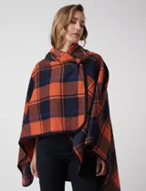 Capa de tejido cuadrille en tonos naranja y azul marino, con cierre frontal mediante botón tipo trenca y bordes ribeteados en negro.