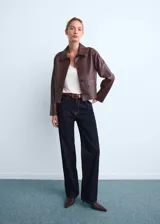 Jeans rectos de tiro medio color azul oscuro, con cinco bolsillos, trabillas para cinturón y cierre frontal con botón y cremallera.