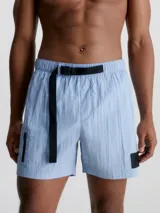 Bañador corto de largo medio Calvin Klein CK Nylon, color celeste, con cintura elástica, cordón ajustable, cinturón de cinta con hebilla y logo, bolsillos laterales y bolsillo trasero con cremallera.
