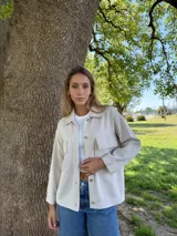 Campera color beige tejida en algodón, de corte recto y manga larga.