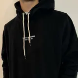 Canguro color caqui con capucha y cordón ajustable. Estampado en la espalda con la frase "The essence of living life fully and energetically", el logo "vibrant journeys", la frase "live for the present" y una cita de Santa Barbara.