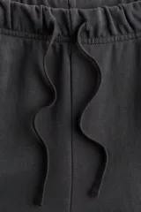 Jogging de felpa liviana en color gris oscuro, con cintura elástica ajustable mediante cordón, bolsillos laterales discretos y diseño de piernas rectas.