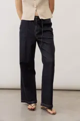 Jean azul oscuro de corte wide leg, con cintura elástica ajustable mediante cordón y bolsillos laterales.
