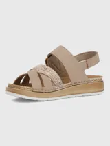 Sandalia de plataforma baja color beige con tiras cruzadas, una de ellas con acabado texturizado brillante. Presenta una tira ajustable con hebilla decorativa y cierre de velcro, sobre una suela de estilo yute con base de poliuretano.