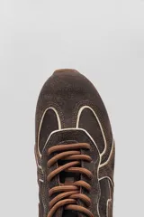 Championes deportivos color marrón con diseño de líneas onduladas en tono claro, cordones al tono y suela de goma.