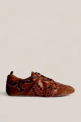 Championes de perfil bajo con diseño de piel de serpiente en tonos marrones y negros, combinados con detalles de gamuza en la puntera, los laterales y el talón, con cordones a tono.