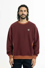 Buzo bordó de corte oversize con cuello redondo, puños y cintura acanalados en color marrón. Presenta paneles laterales con vivo blanco y logo Vernal bordado en el pecho.