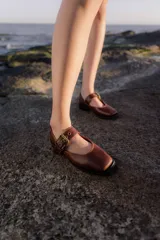 Zapatos tipo Mary Jane color marrón con hebilla dorada y punta cuadrada.