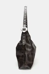 Bolso de hombro formato shopper con acabado efecto cuero desgastado. Cuenta con asa ajustable mediante hebilla metálica y detalle de tachas, cierre principal mediante imán y bolsillo interior con cremallera.