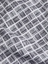 Remera Calvin Klein de corte regular fit y cuello redondo, con estampado integral de cuadros abstractos en tonos blanco y negro.