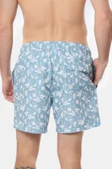 Short de baño celeste con estampado floral blanco, cintura con elástico y cordón regulable, bolsillos laterales y suspensor de malla fina.