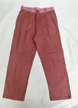 Pantalón de lino color ladrillo con cintura alta y corte holgado, con bolsillos laterales y pinzas.