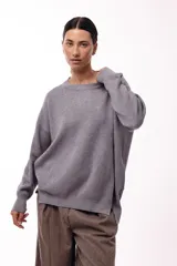 Sweater de punto con cuello redondo, mangas largas con hombros caídos y silueta relajada.