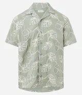 Camisa de calce comfort de la marca Marfinno, confeccionada en algodón color verde con bordado de hojas blancas. Posee cuello con solapa, manga corta y cierre frontal con botones.