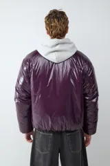 Campera acolchada de acabado brillante en color violeta oscuro, con cuello alto y cierre frontal con cremallera.