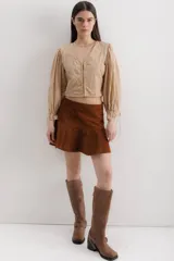 Minifalda color beige de cuero con volados en el ruedo.