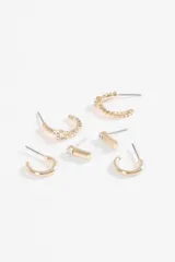 Set de tres pares de aros dorados. Incluye un par de aros tipo barra con strass, un par de aros tipo argolla lisa y un par de aros tipo argolla con textura y strass.