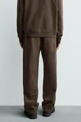 Pantalón jogger de corte regular fit y color negro, confeccionado en tejido compacto de algodón con interior de rizo. Cuenta con cintura elástica, bolsillos frontales y un bolsillo trasero de doble vivo.