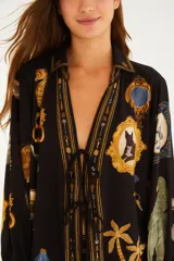 Blusa negra de viscosa con mangas largas y puños ajustables, escote en V con lazos frontales y silueta fluida, con estampado artístico de marcos, animales y elementos marinos.