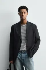 Blazer de corte relajado confeccionado en lino italiano, con cuello de solapas de muesca, cierre frontal de un botón, bolsillo de vivo en el pecho y bolsillos de plastrón en la cadera.