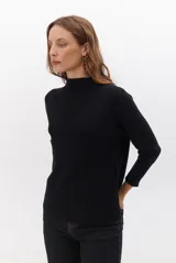 Polera de tejido de punto en color beige, con cuello alto y mangas largas con puños acanalados.
