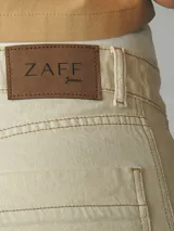 Pantalón de jean color natural, de corte ancho con costuras a la vista y terminación desflecada.