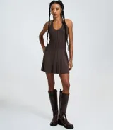 Vestido sin mangas, color marrón oscuro, con escote tipo halter y lazo en el cuello. El tejido es de malla con efecto tricot texturizado acanalado.