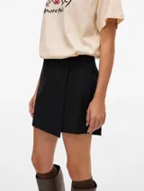 Pollera short de tiro alto y fit holgado, con diseño envolvente en la parte delantera y cierre lateral invisible.