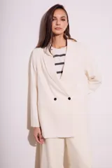 Blazer color crema de poliéster y viscosa, de corte oversize con solapas y doble botonadura.