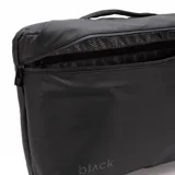 Mochila urbana de diseño minimalista en color negro, con compartimento principal con cierre y asa superior reforzada. Presenta el logo de la marca en la parte inferior frontal.