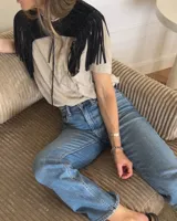 Pechera de cuero vacuno en color negro, diseñada con flecos largos y cierre frontal mediante lazo. Es un accesorio versátil tipo cuello para complementar prendas básicas.