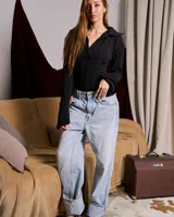 Body negro de manga larga con cuello camisero y corte inferior tipo tanga.