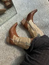 Bota texana de caña media color marrón con detalles en beige y puntera fina.