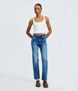 Pantalón de jean azul con corte recto y tiro alto. Presenta un acabado con efecto marmorizado, trabillas en la cintura, cierre frontal con botón y bolsillos laterales y traseros.