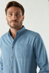 Camisa de jean manga larga con fit regular, cuello con botones, bolsillo frontal y logo bordado.