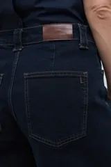 Bermuda de jean en color azul oscuro, con corte recto y largo hasta la rodilla. Presenta costuras a la vista en tono contrastante, cierre frontal con botón y bolsillos laterales.