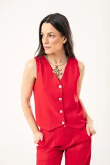 Chaleco rojo con escote en V, sin mangas y cierre frontal con botones. Confeccionado en lino imperial con lurex.