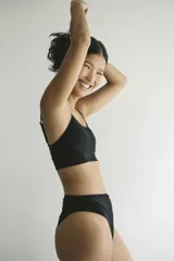 Top de bikini negro, estilo deportivo o bralette, con tirantes finos ajustables y banda ancha bajo el busto.