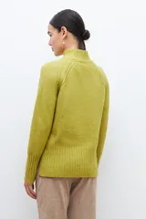Polera de punto color verde pistacho, de corte holgado y cuello alto.