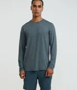 Remera deportiva de manga larga con cuello redondo, confeccionada en tejido tecnológico con tecnología dry de secado rápido. Presenta un diseño liso en tono azul grisáceo, ideal para actividades físicas y uso casual.