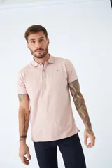 Chomba manga corta color rosa pálido, de corte regular, con cuello clásico con botones, logo bordado en el pecho y terminaciones con ribete en contraste. Confeccionada en algodón y spandex.