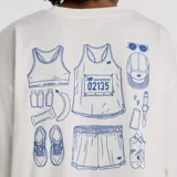 Remera de corte oversize color blanco, con cuello redondo y mangas cortas. Presenta un pequeño estampado gráfico en color azul en el lado izquierdo del pecho.